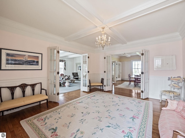 431 Michigan Ave, Charlevoix, MI 49720 - living area with a chandelier, a decorative wall, beamed ceiling, wood finished floors, and ornamental molding