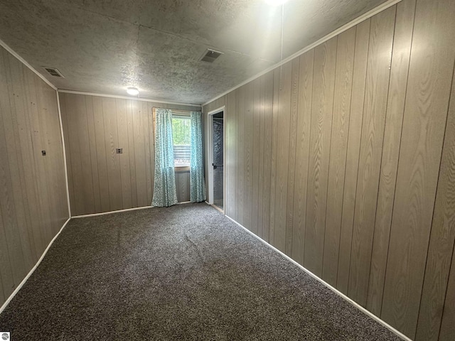 142 Forest Trl, Leroy, MI 49655 - carpeted spare room featuring wood walls, crown molding, and a textured ceiling