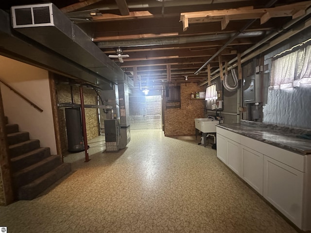 142 Forest Trl, Leroy, MI 49655 - below grade area featuring gas water heater, heating unit, a sink, and stairs