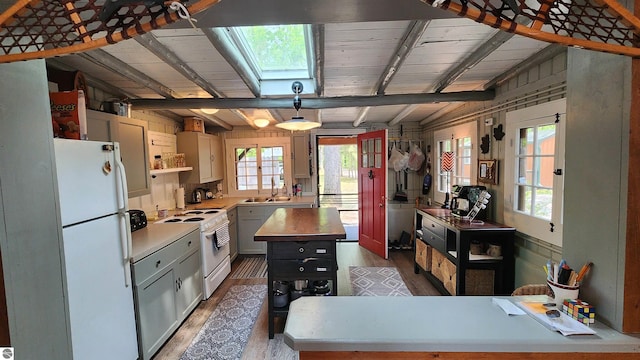 6875 Jose Lake Rd, South Branch, MI 48761 - kitchen with white appliances, a skylight, dark wood finished floors, beamed ceiling, and a center island