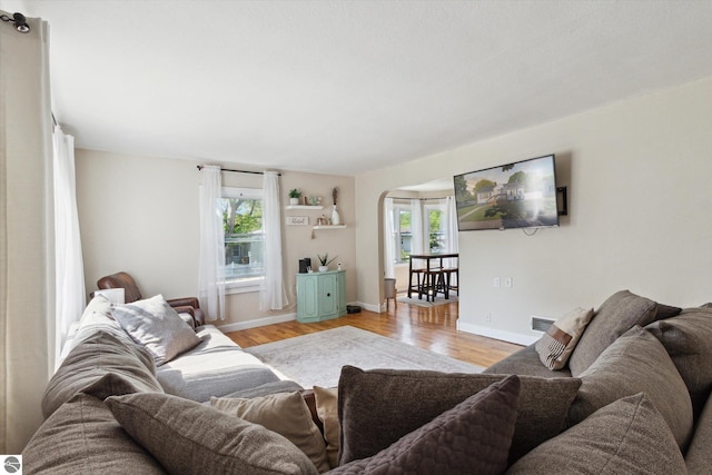 140 S State St, Alma, MI 48801 - living area with arched walkways, plenty of natural light, light wood-style flooring, and baseboards
