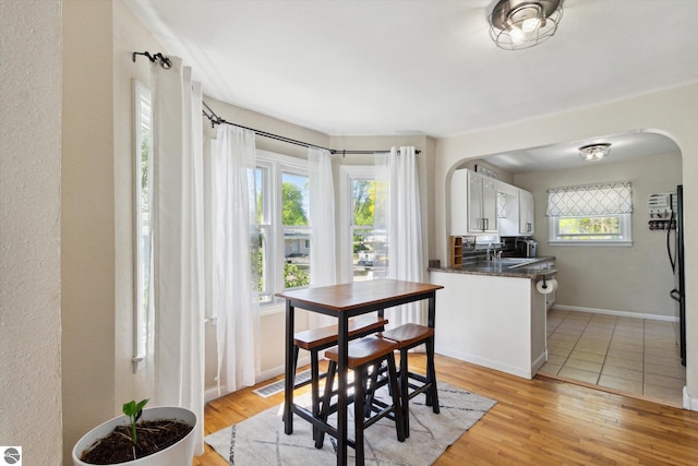 140 S State St, Alma, MI 48801 - dining room featuring arched walkways, light wood-style floors, and baseboards