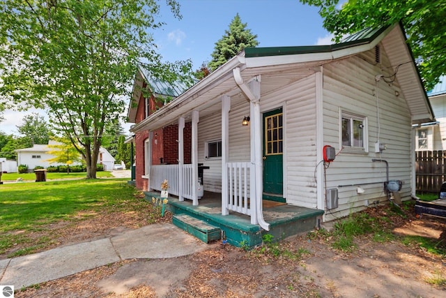 618 N River Ave, Alma, MI 48801 - view of front of house with covered porch and a front yard