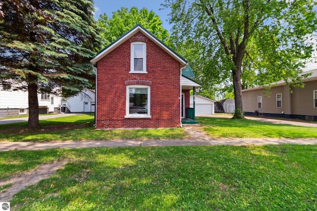 618 N River Ave, Alma, MI 48801 - view of front of property with brick siding, a front yard, an outbuilding, and a detached garage