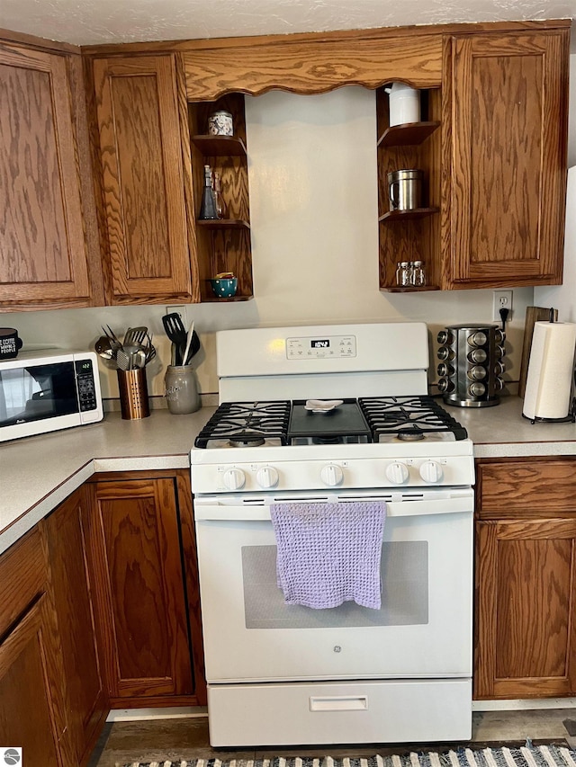 7813 Standish Rd, Bentley, MI 48613 - kitchen featuring white appliances, open shelves, brown cabinetry, and light countertops