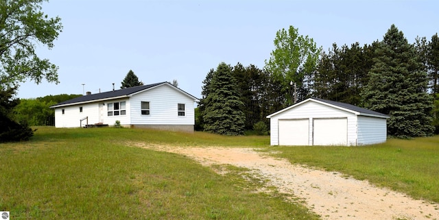 7700 N Caris Rd, Vestaburg, MI 48891 - view of grassy yard featuring a detached garage and an outbuilding