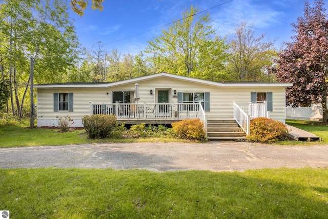 14501 Williams Dr, Elk Rapids, MI 49629 - manufactured / mobile home featuring a deck and a front lawn