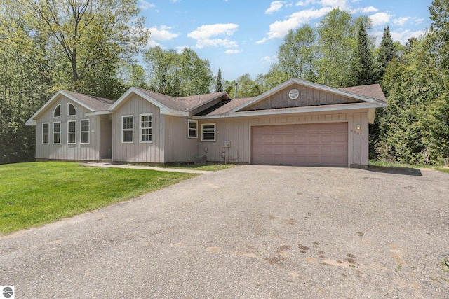6997 W Woodlea Rd, Oscoda, MI 48750 - single story home featuring driveway, an attached garage, and a front yard