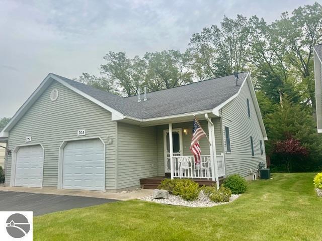 705 Eastgate Pl Unit 10 B, Traverse City, MI 49686 - ranch-style home with covered porch, a garage, driveway, a front lawn, and central AC unit