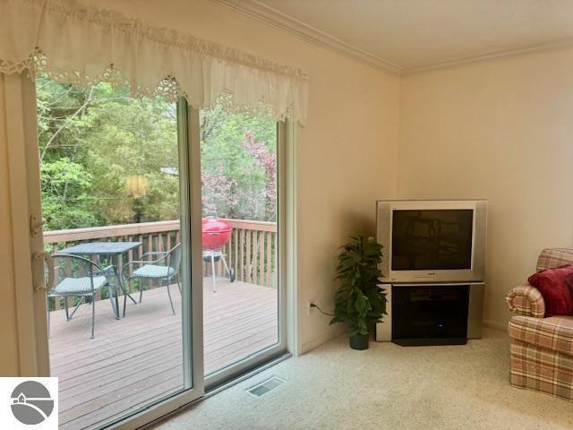 705 Eastgate Pl Unit 10 B, Traverse City, MI 49686 - entryway featuring crown molding, healthy amount of natural light, and carpet flooring