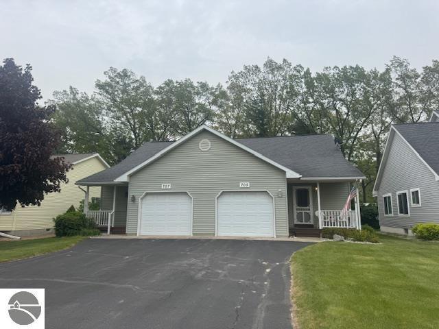 705 Eastgate Pl Unit 10 B, Traverse City, MI 49686 - view of front of property featuring a garage, a porch, asphalt driveway, and a front yard