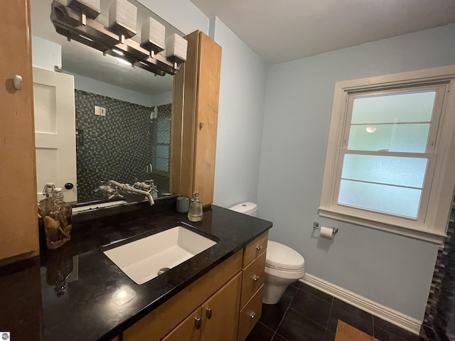 906 Vassar St, Alma, MI 48801 - bathroom with tile patterned floors, toilet, tiled shower, vanity, and baseboards