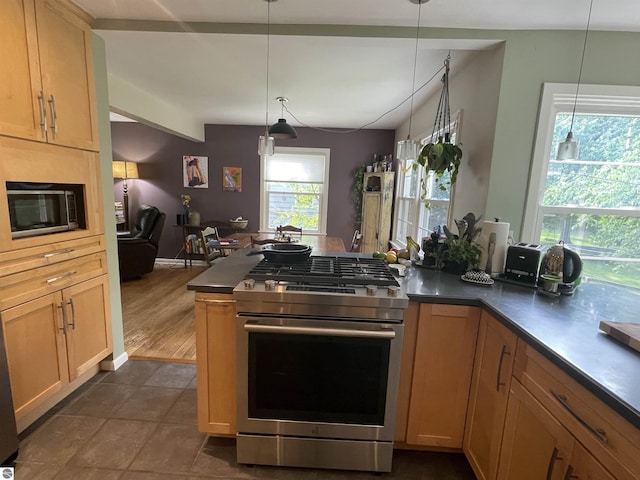 906 Vassar St, Alma, MI 48801 - kitchen featuring gas range, dark countertops, open floor plan, and hanging light fixtures