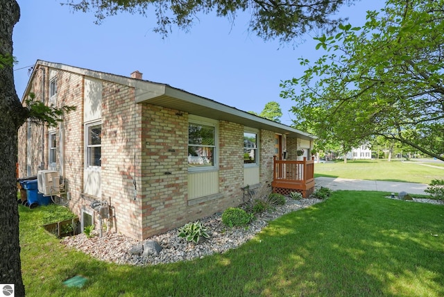 710 E Division St, Cadillac, MI 49601 - view of home's exterior featuring brick siding, a lawn, and a chimney