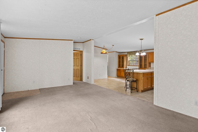 11748 NE Franklin St, Kalkaska, MI 49646 - unfurnished living room featuring ornamental molding, light carpet, and a chandelier