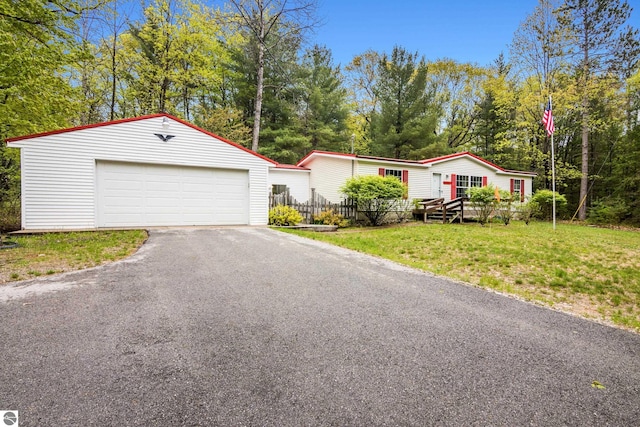 11748 NE Franklin St, Kalkaska, MI 49646 - manufactured / mobile home featuring an outdoor structure, a detached garage, and view of wooded area