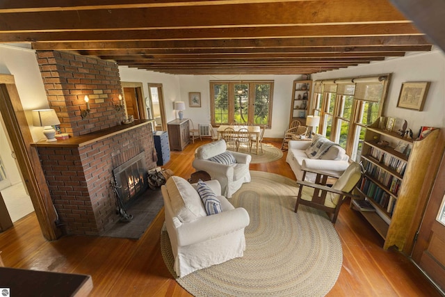 1884 Beech Rd, Frankfort, MI 49635 - living area with beam ceiling, wood-type flooring, and a fireplace