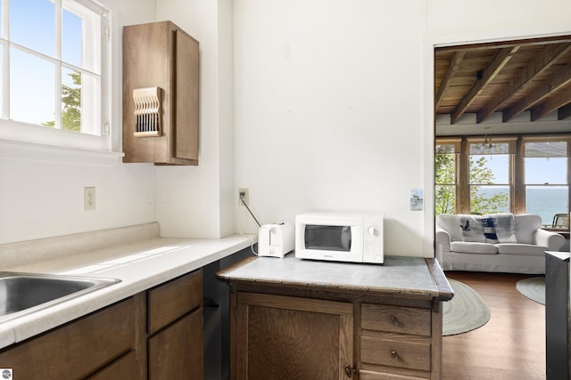 1884 Beech Rd, Frankfort, MI 49635 - kitchen featuring white microwave, light countertops, wood ceiling, wood finished floors, and a sink