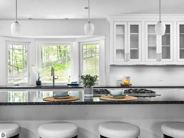 107 Hillcrest Ct, Traverse City, MI 49684 - kitchen featuring a sink, white cabinets, a breakfast bar, and plenty of natural light