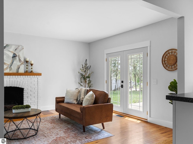 107 Hillcrest Ct, Traverse City, MI 49684 - sitting room featuring french doors, light wood-type flooring, baseboards, and a fireplace