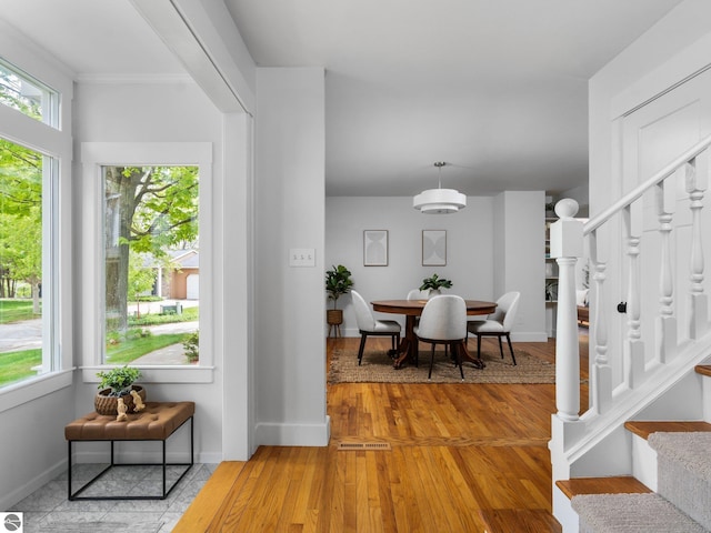 107 Hillcrest Ct, Traverse City, MI 49684 - dining room with stairway, light wood-type flooring, baseboards, and crown molding