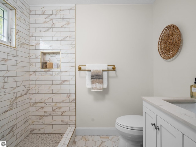 107 Hillcrest Ct, Traverse City, MI 49684 - bathroom featuring a tile shower, toilet, vanity, tile patterned floors, and baseboards