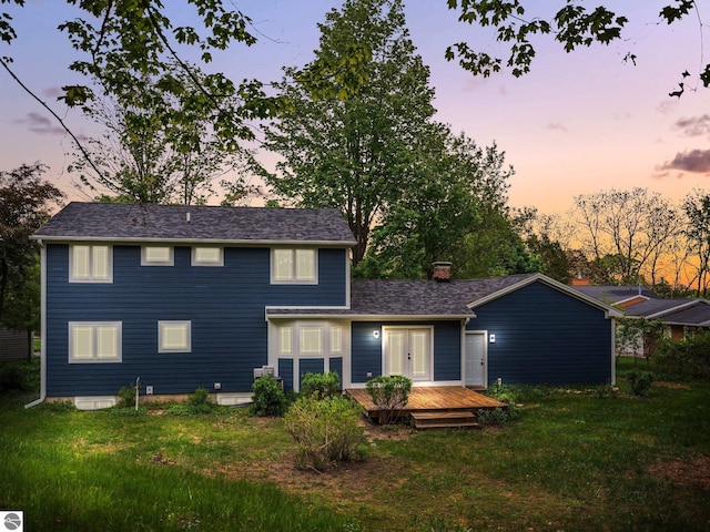107 Hillcrest Ct, Traverse City, MI 49684 - view of front of house featuring a wooden deck, a front yard, a chimney, and french doors