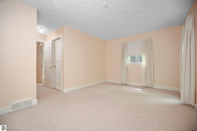 1631 Melody Ln, Interlochen, MI 49643 - unfurnished room with light carpet, baseboards, and a textured ceiling
