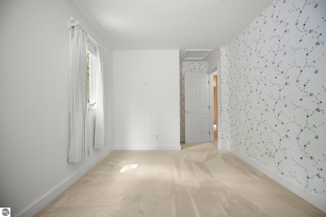 1631 Melody Ln, Interlochen, MI 49643 - spare room featuring wallpapered walls, attic access, light carpet, and baseboards