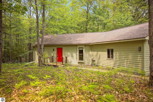 1631 Melody Ln, Interlochen, MI 49643 - view of front facade featuring roof with shingles and a wooded view