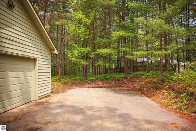 1631 Melody Ln, Interlochen, MI 49643 - view of patio with a garage, driveway, and a forest view
