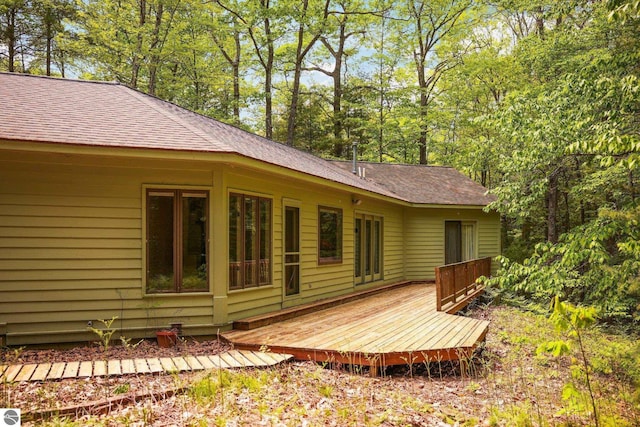 1631 Melody Ln, Interlochen, MI 49643 - rear view of property featuring a shingled roof and a wooden deck