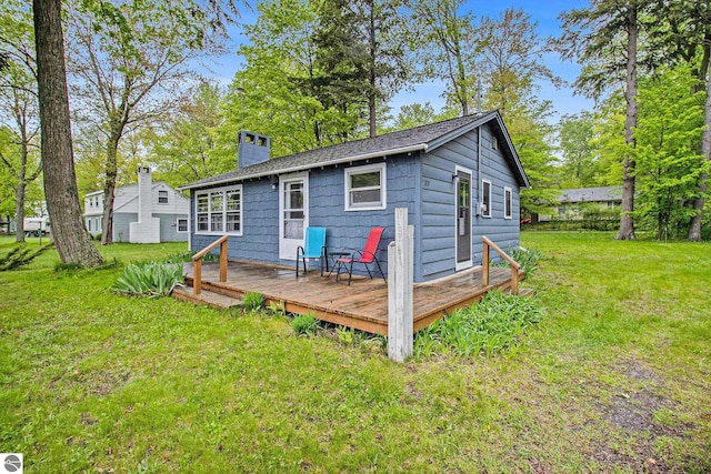 3131 Herron Rd, Frankfort, MI 49635 - rear view of property with a deck, a chimney, and a yard