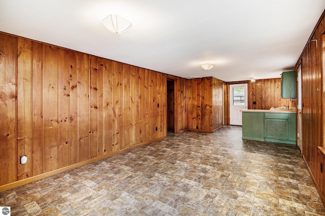 3131 Herron Rd, Frankfort, MI 49635 - unfurnished living room with wooden walls, stone finish floors, baseboards, and a sink
