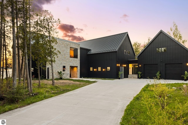 9371 Onominese Trl, Northport, MI 49670 - modern farmhouse featuring a standing seam roof, concrete driveway, board and batten siding, stone siding, and a garage