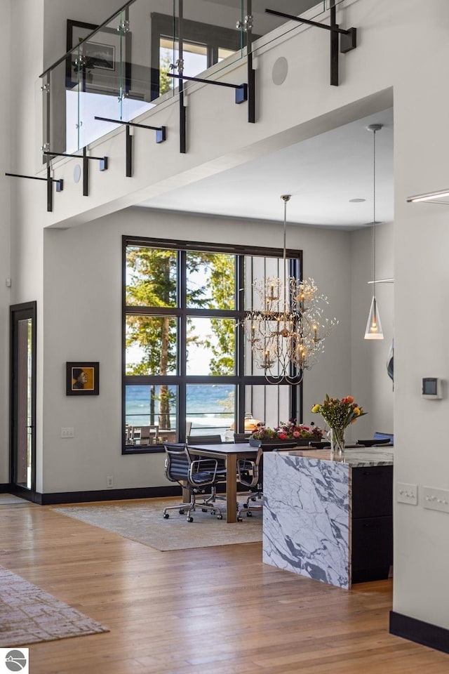 9371 Onominese Trl, Northport, MI 49670 - bar area featuring a high ceiling, wood finished floors, baseboards, a chandelier, and hanging light fixtures