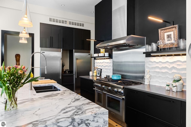 9371 Onominese Trl, Northport, MI 49670 - kitchen with dark cabinets, high quality appliances, wall chimney range hood, modern cabinets, and a sink