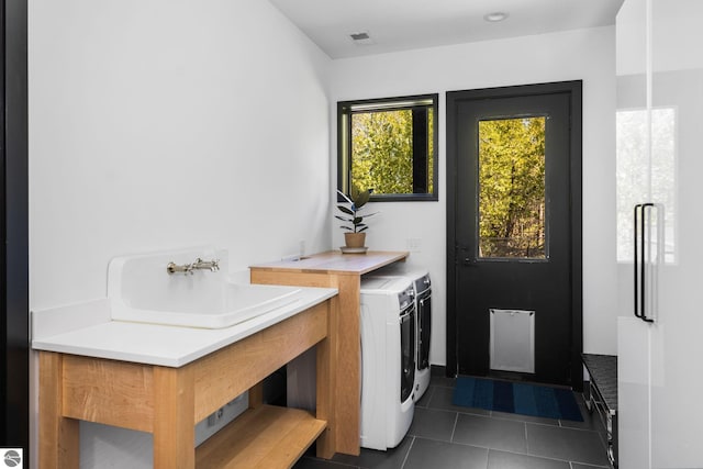 9371 Onominese Trl, Northport, MI 49670 - washroom featuring dark tile patterned flooring and washer and clothes dryer