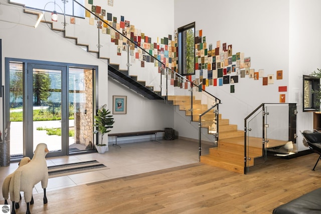 9371 Onominese Trl, Northport, MI 49670 - entrance foyer featuring a towering ceiling, stairway, and wood finished floors