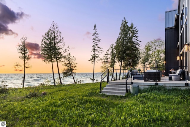 9371 Onominese Trl, Northport, MI 49670 - yard at dusk with a water view, an outdoor living space, and a lawn