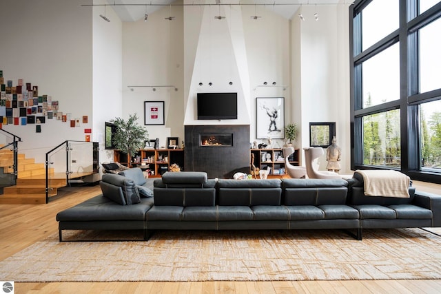 9371 Onominese Trl, Northport, MI 49670 - living room with a towering ceiling, wood-type flooring, and a glass covered fireplace