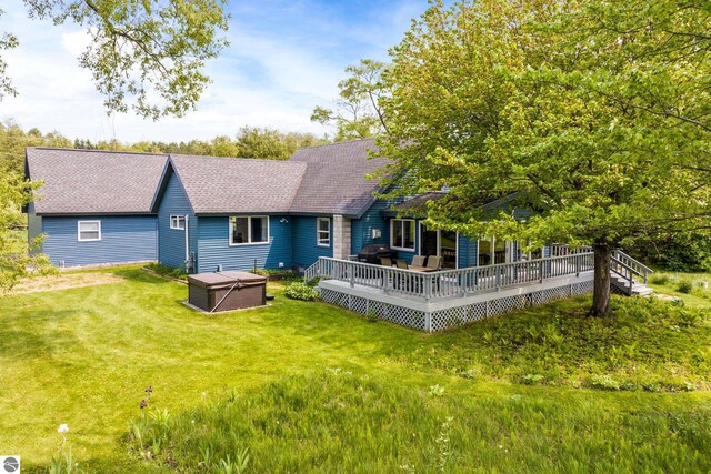 3802 S Grants Lndg, Lake Leelanau, MI 49653 - rear view of house with a hot tub, a shingled roof, a lawn, and a deck