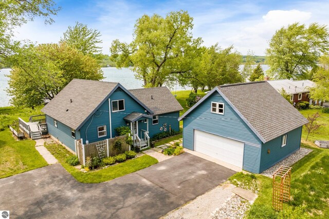 3802 S Grants Lndg, Lake Leelanau, MI 49653 - view of front of home featuring a shingled roof, a detached garage, a front yard, and driveway