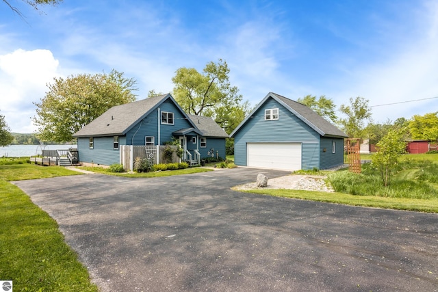 3802 S Grants Lndg, Lake Leelanau, MI 49653 - view of front of home with an outdoor structure, a detached garage, roof with shingles, and a deck