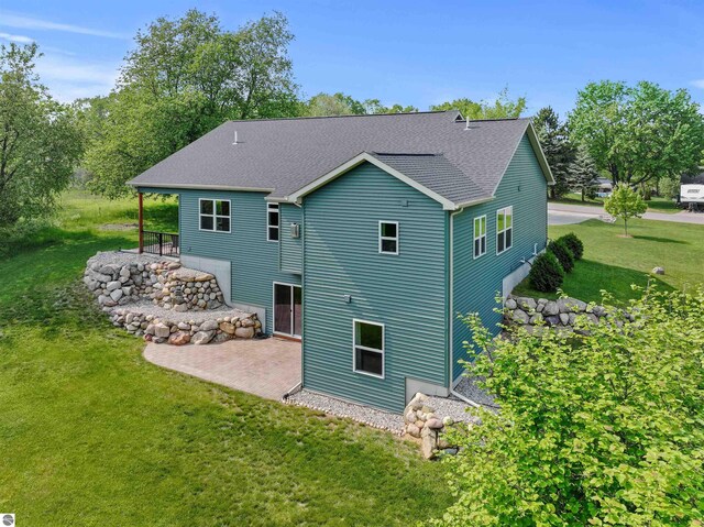 9207 Mockingbird Ln, Cadillac, MI 49601 - back of property with a patio, a yard, and a shingled roof