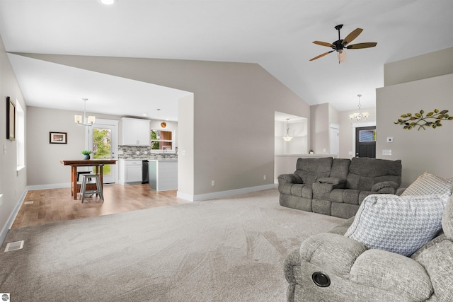 9207 Mockingbird Ln, Cadillac, MI 49601 - living area with a chandelier, light carpet, baseboards, and high vaulted ceiling