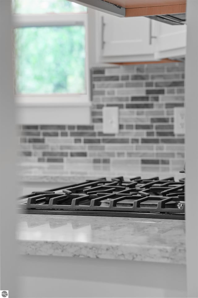 9207 Mockingbird Ln, Cadillac, MI 49601 - kitchen view of backsplash, white cabinets, and light stone countertops