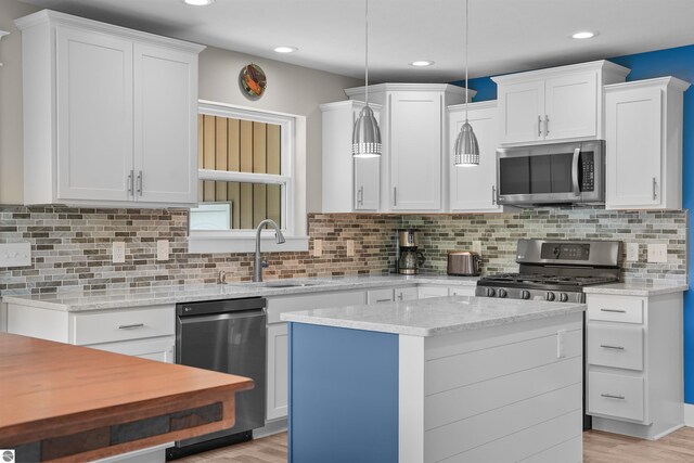 9207 Mockingbird Ln, Cadillac, MI 49601 - kitchen with stainless steel appliances, a sink, white cabinetry, light wood finished floors, and recessed lighting