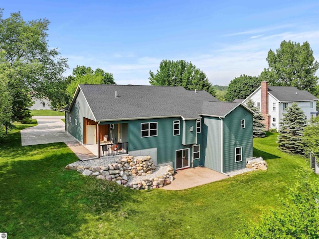 9207 Mockingbird Ln, Cadillac, MI 49601 - rear view of house featuring a patio area, a lawn, and roof with shingles