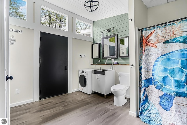 100 Fence Row Cir, Leroy, MI 49655 - bathroom with toilet, wood finished floors, vanity, a towering ceiling, and baseboards